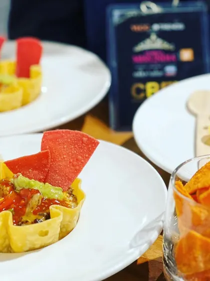 A deconstructed taco bowl served at the Femina Miss India event, featuring a crispy tortilla shell filled with beans, salsa, and guacamole.