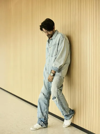 A full view of the relaxed denim-on-denim look. The loose fit and ripped jeans give it a comfortable yet stylish edge.