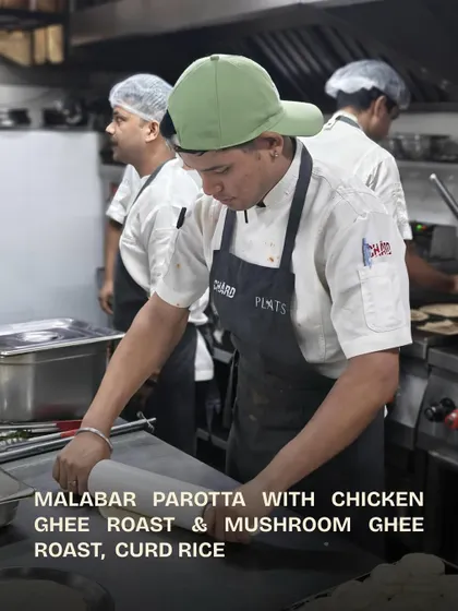 A chef carefully rolling out the dough for Malabar Parottas.
