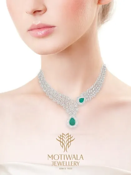 Inspired by nature's delicate forms, this diamond and emerald necklace is for the modern woman who appreciates subtle luxury. The pear-shaped emerald drop adds a touch of color to the intricate, leaf-like diamond setting.