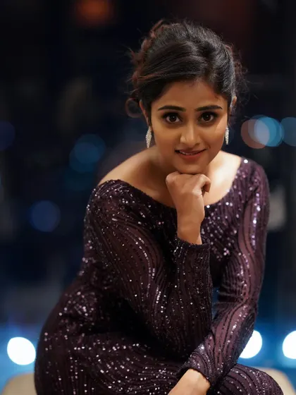 A beautiful portrait with a soft bokeh background. The city lights at night create a lovely, out-of-focus pattern that makes the subject in her sparkling dress stand out.