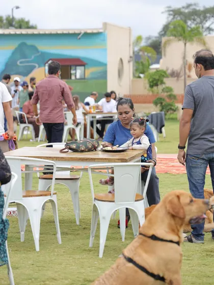 A mother and her child enjoying a meal at our Bark & Brunch event, with a happy Labrador in the foreground. Our events are designed to be family-friendly for all ages.
