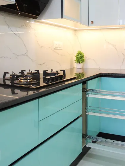 This modern kitchen in a vibrant turquoise finish features a pull-out bottle and spice rack next to the hob. This ensures cooking essentials are always within easy reach.