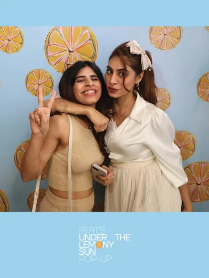 Two friends enjoying the sunny vibes at the PTAT pop-up. Our booth becomes a go-to spot for capturing the perfect social media picture.
