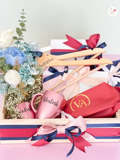 A complete hamper featuring personalized hangers, custom mugs, and an embroidered pouch, all in a coordinated red and blue theme.