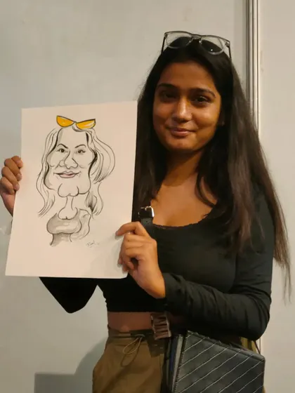 A guest at a Redbull event, happy with her fun and quirky caricature.