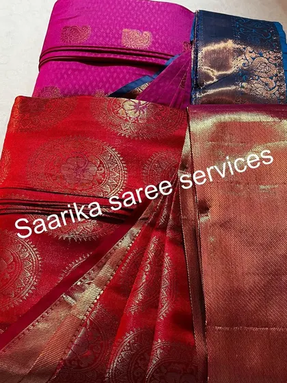 A red and a pink saree, folded and stacked. This shows how neatly they can be stored.