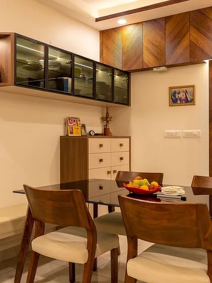 This dining area is all about balance. Warm chevron wood panels provide natural charm, while sleek, dark-paned glass cabinets add a fresh, modern touch. It's the perfect blend of classic and contemporary.