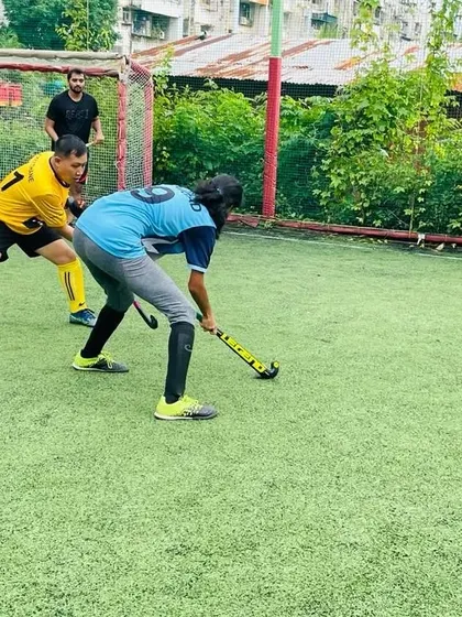 A female player skillfully controls the ball while a male player defends. Our mixed practice sessions promote mutual respect and a high level of competition.