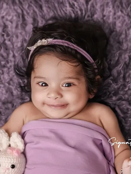 A happy and smiling four-month-old baby girl, her personality shining through.