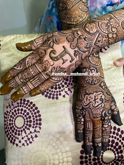 A close-up of the personalized 'F' bridal mehendi, showing the intricate details on the palms.
