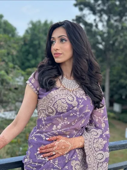 A still shot of the purple saree look, showing the intricate silver embroidery. The simple drape allows the saree's beauty to be the main focus.