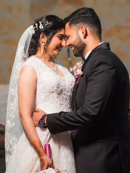 Shreya and Wayne share a happy, intimate moment at the altar after their Christian wedding ceremony.
