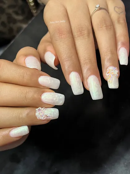 This white-on-white design uses texture and 3D bows to create a subtle yet stunning effect. It's a great example of sophisticated nail artistry.