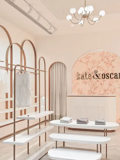 The central display tables are designed with soft, rounded shapes and rose gold legs, continuing the store's gentle and elegant aesthetic.