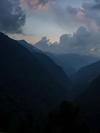 The journey to Annapurna Base Camp begins. As twilight settles over the valley, the mountains create a dramatic silhouette, promising days of adventure ahead.
