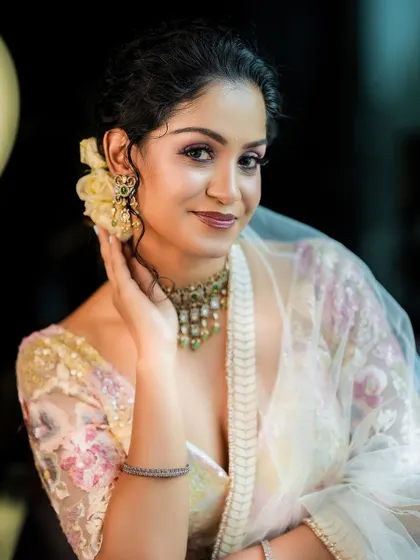 A classic beauty shot. The model's hand gently touching her face draws attention to her features and the delicate earrings.