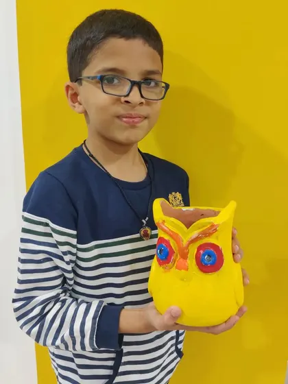 Another happy guest from the animal-themed party, holding his brightly painted owl planter.