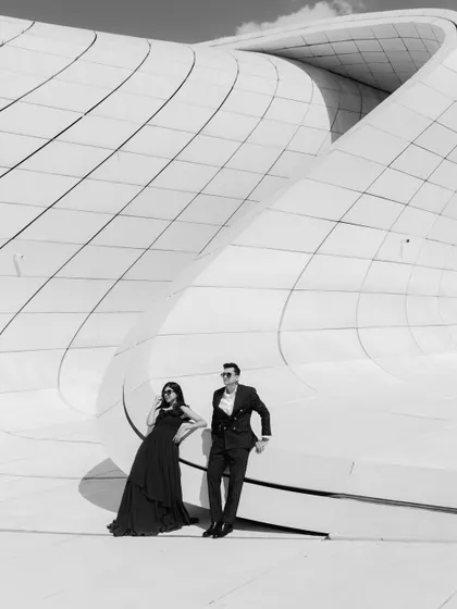 A dramatic black and white pre-wedding portrait in Baku. The sweeping lines of the modern architecture create a powerful graphic element, making the couple look like stars in their own epic.