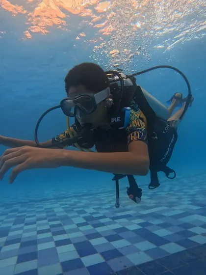 A participant experiences the unique sensation of breathing underwater during our introductory scuba diving session in Malpe. We conduct these initial lessons in the safety of a swimming pool to build confidence and teach essential skills.