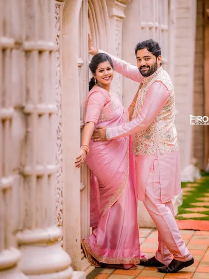A romantic pose against a backdrop of white pillars. The couple's matching pink outfits and their happy expressions make this a beautiful pre-wedding portrait.