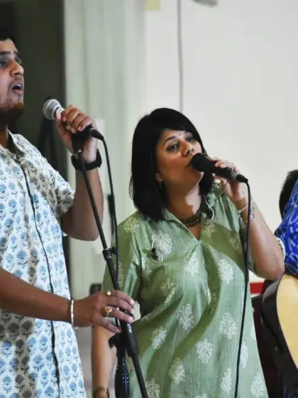 Volunteers sing and play music as part of a satsang. Seva isn't limited to physical tasks; sharing one's artistic talents is also a beautiful form of service.