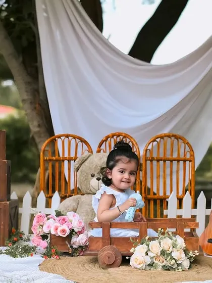 The birthday girl enjoying a ride in a little wooden wagon. Outdoor sessions allow for playful and interactive shots like this.