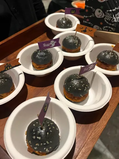 Spooky mini sliders with black charcoal buns, made for a Halloween-themed catering event. Each one had a little flag for extra fun.