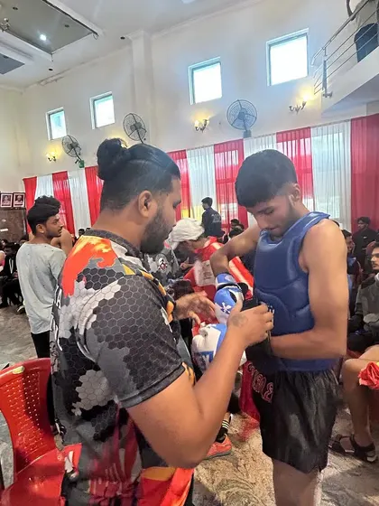 The final moments before a fight are crucial. I'm here ensuring my fighter's gear is secure and his mind is focused on the task ahead.