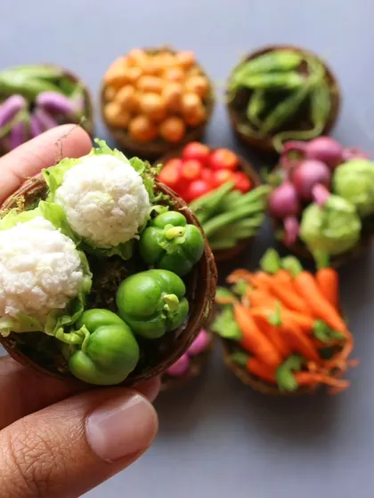 A close-up of a basket of miniature cauliflower and capsicum.