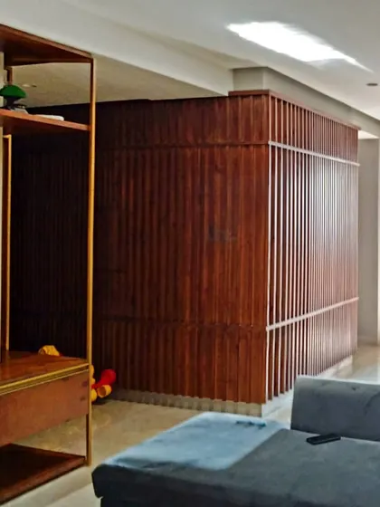 A view of the 'concave' wooden pocket in the Gurgaon residence, which wraps around a section of the living area. This architectural furnishing helps to zone the open-plan space, creating a cozier, more intimate setting for the seating area.