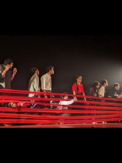 The ensemble cast of 'Sea's Fire' looks towards a single point of light, a symbol of hope within the narrative of the performance.