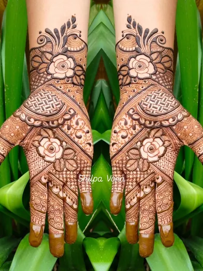 A symmetrical floral design with shaded roses, set against a lush green background.