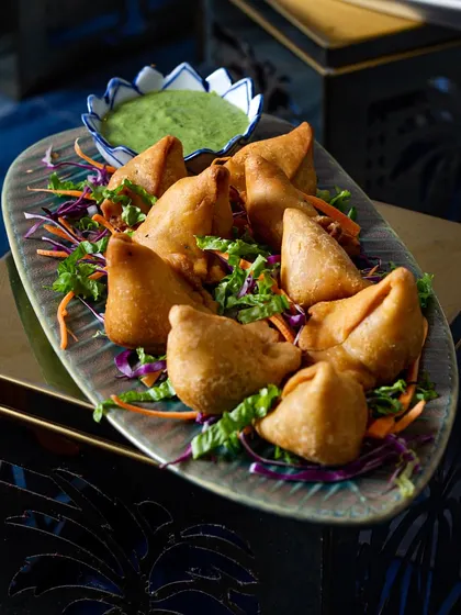 The classic mini samosa, a timeless Indian snack that we serve hot and fresh with tangy chutney.