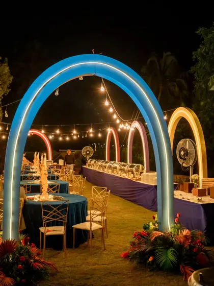 The dining area for our cosmic-themed sangeet. Glowing arches in blue, orange, and pink framed the buffet stations, creating a vibrant and futuristic dining experience under string lights.