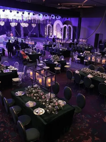 An overhead view of a large ballroom configured for a gala dinner. This perspective shows the meticulous planning of the floor layout, with a mix of rectangular and round tables, ensuring clear sightlines to the stage and comfortable guest flow.