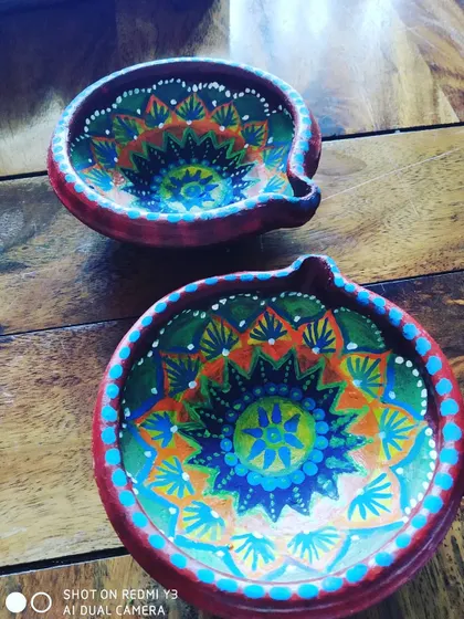 Here are two of my hand-painted terracotta diyas, perfect for Diwali. I use bright acrylic paints to create detailed mandala patterns, ensuring each piece is a unique work of art for your festive celebrations.