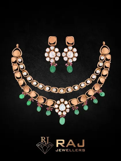 From the Raagini Collection by Revaj, this necklace set is a symphony of elegance. The design features two layers of polki-studded elements, with delicate drops of emerald-green beads adding a touch of vibrant color and grace.