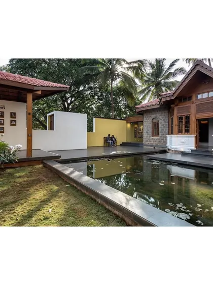 The restored colonial building is framed by the new landscape elements, creating a dialogue between the past and the present.