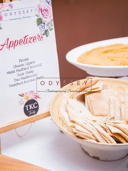 A menu for an appetizer station, placed next to a bowl of pita bread and hummus. We ensure our menus are clear, elegant, and match the event's decor.