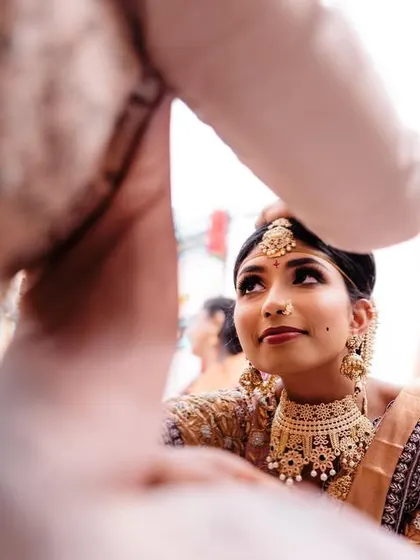 A beautiful moment during the Jeelakarra Bellam ceremony, where the bride looks up at her groom. Our focus is on the meaningful glances and rituals that define a wedding.