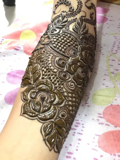 A detailed shot of a bridal arm piece, focusing on the traditional fish and floral motifs.