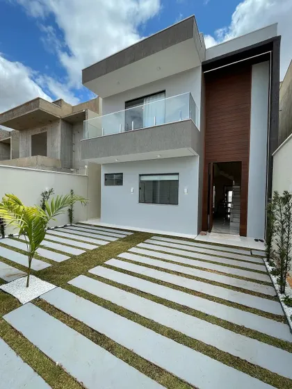 A modern driveway solution using large concrete pavers separated by strips of grass. This design creates a clean, linear look that enhances the home's contemporary facade while allowing for water drainage.
