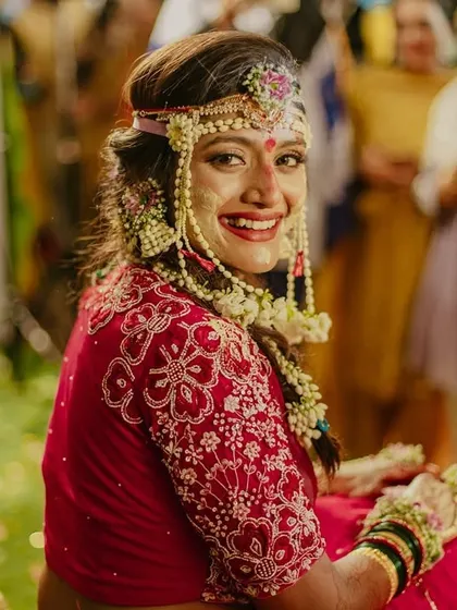 A beautiful, candid shot of the bride smiling during her Haldi ceremony, adorned with floral jewelry.