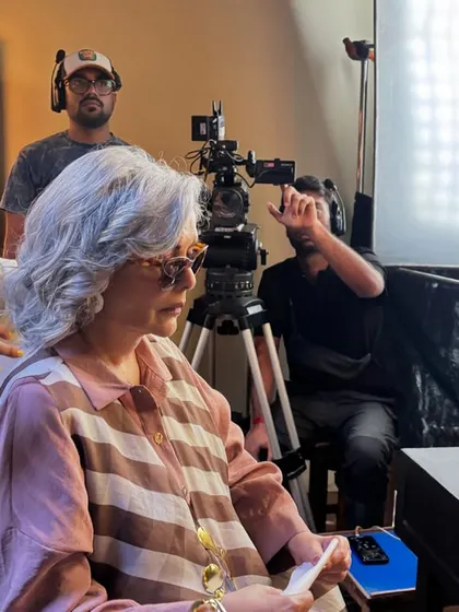 On set, making final adjustments for Zeenat Aman's look. This is where the magic happens, ensuring every detail of the outfit is perfect for the camera.