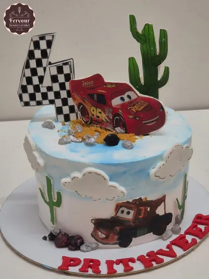 A Disney Cars-themed cake featuring Lightning McQueen and Mater in a desert scene. The design includes edible cacti and a checkered flag, perfect for a little racing fan's 4th birthday.