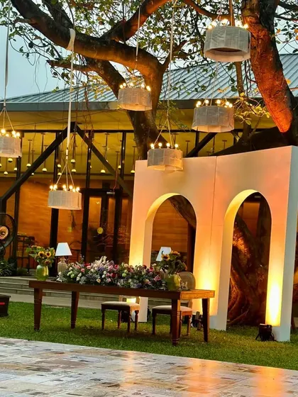 The sweetheart table and dance floor setup for the garden reception, with custom chandeliers hanging from the tree branches.