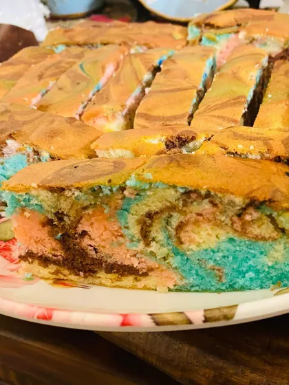 A close-up slice of my ultra moist Ribbon cake, showing the beautiful marbled colors inside. It's made with love in every layer.