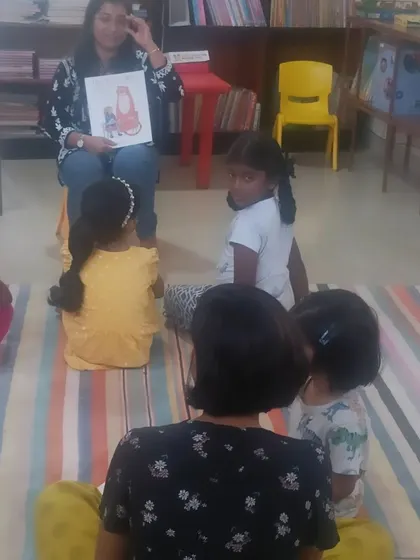 Another view of the storytelling session, showing a mix of toddlers and older children enjoying the story together.