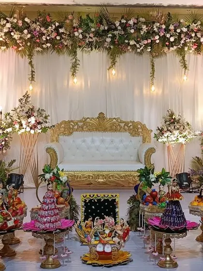 An elegant and dreamy stage setup with hanging floral arrangements and warm lights. My doll-themed gift platters are arranged in front, adding to the magical atmosphere of the event.
